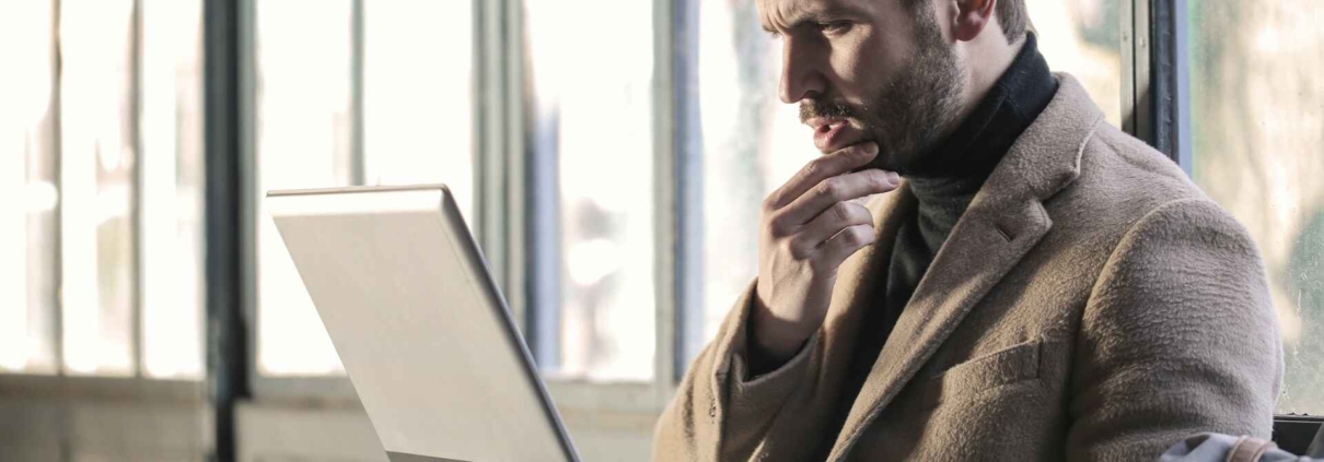 Man looking at his laptop with a worried expression