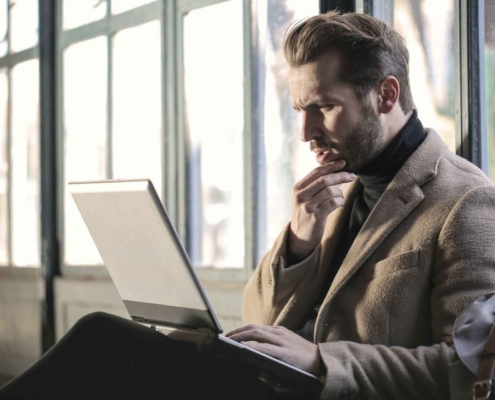 Man looking at his laptop with a worried expression