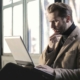 Man looking at his laptop with a worried expression