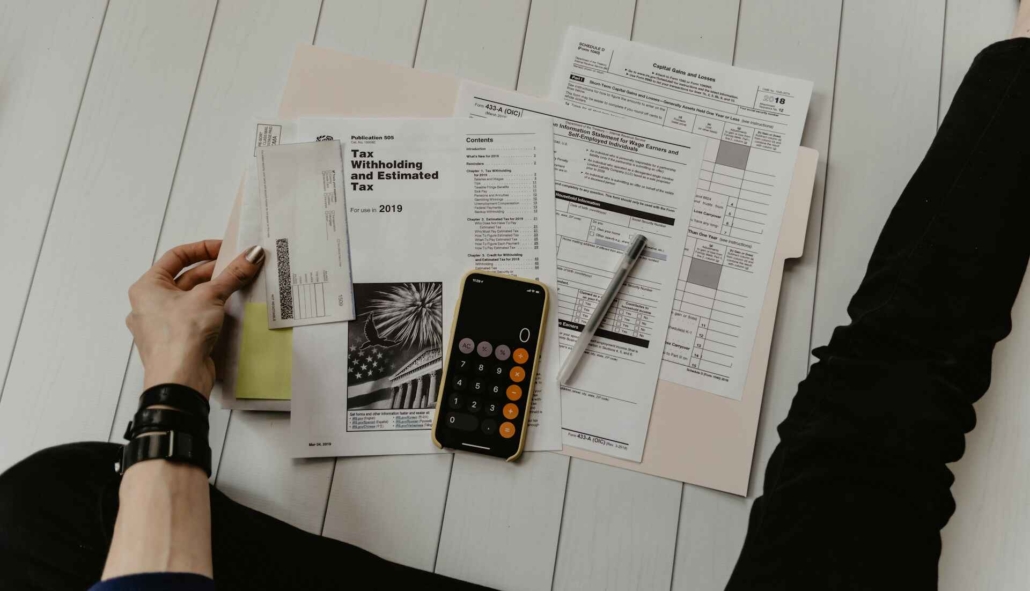 Person pouring over tax forms with a calculator